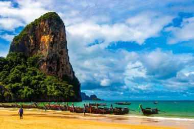 Longtail boat boats at the beautiful famous beach lagoon between limestone rocks and turquoise water on Railay West Beach in Ao Nang Amphoe Mueang Krabi Thailand in Southeast Asia.