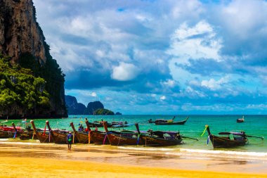 Longtail boat boats at the beautiful famous beach lagoon between limestone rocks and turquoise water on Railay West Beach in Ao Nang Amphoe Mueang Krabi Thailand in Southeast Asia.