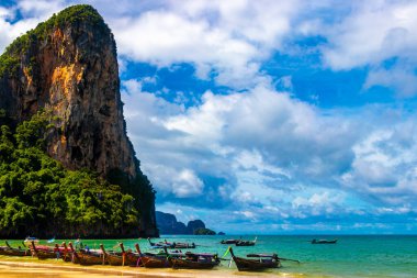 Longtail boat boats at the beautiful famous beach lagoon between limestone rocks and turquoise water on Railay West Beach in Ao Nang Amphoe Mueang Krabi Thailand in Southeast Asia.