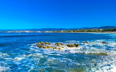 Beautiful rocks cliffs stones boulders and huge big powerful surfer waves on the beach in La Punta Zicatela Puerto Escondido Oaxaca Mexico.