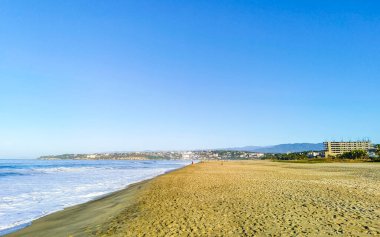 Sun beach sand people waves palms tourism and blue water in Zicatela Puerto Escondido Oaxaca Mexico.