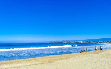 Puerto Escondido Oaxaca Meksika 27. Ocak 2023 Parasols Şemsiyeleri, La Punta Zicatela Puerto Escondido Oaxaca Meksika 'daki tropikal Meksika plajında insanları kaya ve dalgalara boğar..