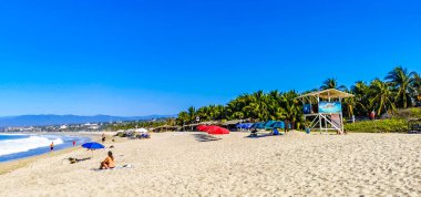 Puerto Escondido Oaxaca Meksika 27. Ocak 2023 Parasols Şemsiyeleri, La Punta Zicatela Puerto Escondido Oaxaca Meksika 'daki tropikal Meksika plajında insanları kaya ve dalgalara boğar..