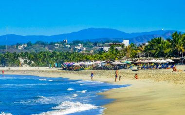 Puerto Escondido Oaxaca Meksika 27. Ocak 2023 Parasols Şemsiyeleri, La Punta Zicatela Puerto Escondido Oaxaca Meksika 'daki tropikal Meksika plajında insanları kaya ve dalgalara boğar..