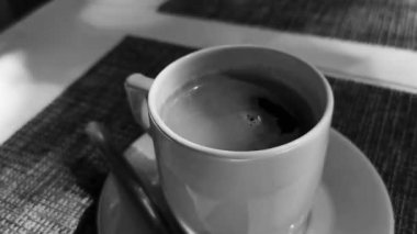 Glass cup of americano black coffee with spoon and plate on table food and drink in the restaurant PapaCharly Papa Charly in Playa del Carmen Quintana Roo Mexico.