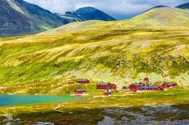 Ellenmemiş doğa nehirleri, kayalar, kayalar ve İskandinavya 'daki Rondane Ulusal Parkı Ringbu Innlandet Norveç' teki kırmızı kulübelerden oluşan güzel dağ ve manzara manzarası..