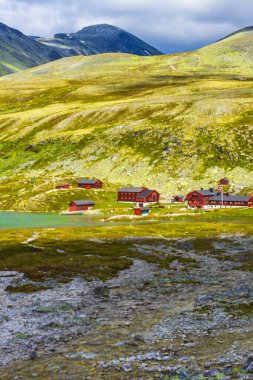 Ellenmemiş doğa nehirleri, kayalar, kayalar ve İskandinavya 'daki Rondane Ulusal Parkı Ringbu Innlandet Norveç' teki kırmızı kulübelerden oluşan güzel dağ ve manzara manzarası..