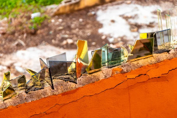 Dangerous wall with broken glass shards bottles in Luis Donaldo Colosio Playa del Carmen Mexico.