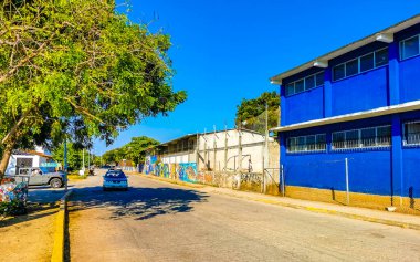 Tipik ve renkli paradisiacal cadde evleri, daireleri restoranları, restoranları, araba dükkanları palmiye ağaçları ve Bacocho ve Rinconada Puerto Escondido Oaxaca Meksika 'daki insanlar..