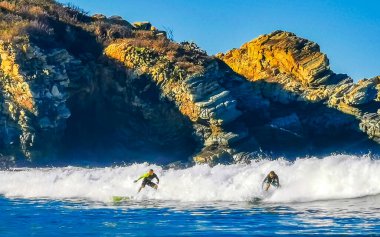 Puerto Escondido Oaxaca Meksika 27. Ocak 2023 Sörfçü sörf tahtasında sörf yapıyor güzel güneşli sahillerde, mavi gökyüzü Zicatela Puerto Escondido Oaxaca Meksika 'da..