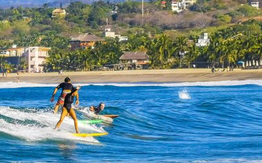 Puerto Escondido Oaxaca Meksika 27. Ocak 2023 Sörfçü sörf tahtasında sörf yapıyor güzel güneşli sahillerde, mavi gökyüzü Zicatela Puerto Escondido Oaxaca Meksika 'da..