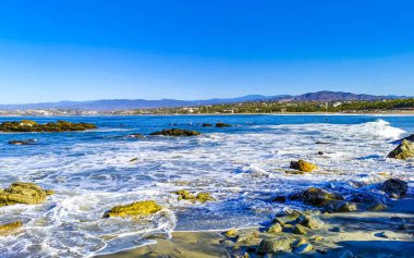 Beautiful rocks cliffs stones and boulders and huge big surfer waves on the beach in La Punta Zicatela Puerto Escondido Oaxaca Mexico.