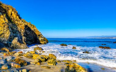 Beautiful rocks cliffs stones and boulders and huge big surfer waves on the beach in La Punta Zicatela Puerto Escondido Oaxaca Mexico.