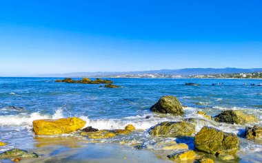 Beautiful rocks cliffs stones and boulders and huge big surfer waves on the beach in La Punta Zicatela Puerto Escondido Oaxaca Mexico.