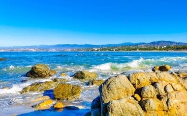 Beautiful rocks cliffs stones and boulders and huge big surfer waves on the beach in La Punta Zicatela Puerto Escondido Oaxaca Mexico.