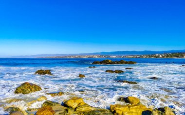 Beautiful rocks cliffs stones and boulders and huge big surfer waves on the beach in La Punta Zicatela Puerto Escondido Oaxaca Mexico.