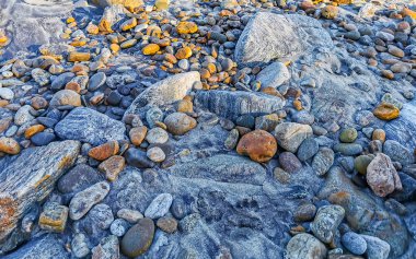 Beautiful rocks cliffs stones and boulders pattern and texture of the beach in La Punta Zicatela Puerto Escondido Oaxaca Mexico.