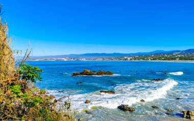 Beautiful rocks cliffs stones and boulders and huge big surfer waves on the beach in La Punta Zicatela Puerto Escondido Oaxaca Mexico.