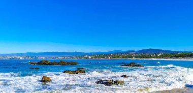 Beautiful rocks cliffs stones and boulders and huge big surfer waves on the beach in La Punta Zicatela Puerto Escondido Oaxaca Mexico.