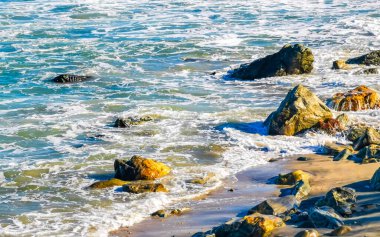 Beautiful rocks cliffs stones and boulders and huge big surfer waves on the beach in La Punta Zicatela Puerto Escondido Oaxaca Mexico.