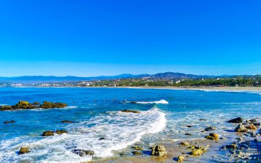 Beautiful rocks cliffs stones and boulders and huge big surfer waves on the beach in La Punta Zicatela Puerto Escondido Oaxaca Mexico.