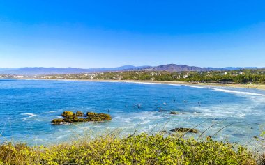 Güzel tropikal ve doğal şehir ve deniz manzarası Pasifik Okyanusu palmiyeleri ve Zicatela Puerto Escondido Oaxaca dalgaları ile plaj manzarası.