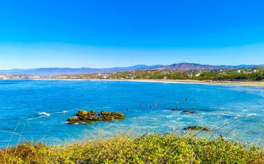 Beautiful tropical and natural city and seascape landscape panorama view with pacific ocean sea palms palm trees and beach with waves of Zicatela Puerto Escondido Oaxaca Mexico.