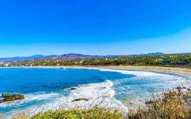 Beautiful tropical and natural city and seascape landscape panorama view with pacific ocean sea palms palm trees and beach with waves of Zicatela Puerto Escondido Oaxaca Mexico.
