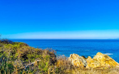 Beautiful tropical and natural city and seascape landscape panorama view with pacific ocean sea palms palm trees and beach with waves of Zicatela Puerto Escondido Oaxaca Mexico.