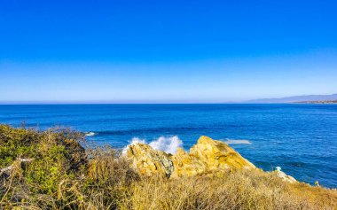 Beautiful rocks cliffs stones and boulders and huge big surfer waves on the beach in La Punta Zicatela Puerto Escondido Oaxaca Mexico.