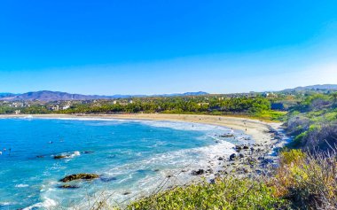 Beautiful rocks cliffs stones and boulders and huge big surfer waves on the beach in La Punta Zicatela Puerto Escondido Oaxaca Mexico.