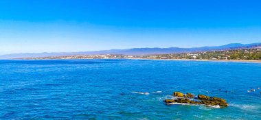 Beautiful rocks cliffs stones and boulders and huge big surfer waves on the beach in La Punta Zicatela Puerto Escondido Oaxaca Mexico.