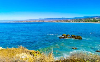 Güzel tropikal ve doğal şehir ve deniz manzarası Pasifik Okyanusu palmiyeleri ve Zicatela Puerto Escondido Oaxaca dalgaları ile plaj manzarası.