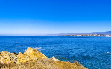 Beautiful rocks cliffs stones and boulders and huge big surfer waves on the beach in La Punta Zicatela Puerto Escondido Oaxaca Mexico.