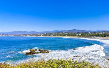 Beautiful tropical and natural city and seascape landscape panorama view with pacific ocean sea palms palm trees and beach with waves of Zicatela Puerto Escondido Oaxaca Mexico.