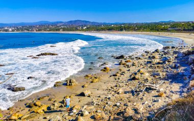 Beautiful rocks cliffs stones and boulders and huge big surfer waves on the beach in La Punta Zicatela Puerto Escondido Oaxaca Mexico.
