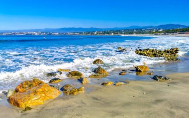 Beautiful rocks cliffs stones and boulders and huge big surfer waves on the beach in La Punta Zicatela Puerto Escondido Oaxaca Mexico.