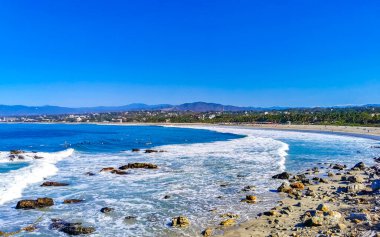 Beautiful rocks cliffs stones and boulders and huge big surfer waves on the beach in La Punta Zicatela Puerto Escondido Oaxaca Mexico.