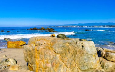 Beautiful rocks cliffs stones and boulders and huge big surfer waves on the beach in La Punta Zicatela Puerto Escondido Oaxaca Mexico.