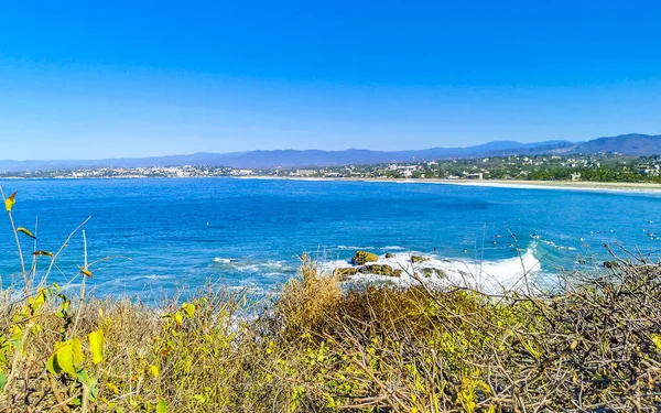 Beautiful tropical and natural city and seascape landscape panorama view with pacific ocean sea palms palm trees and beach with waves of Zicatela Puerto Escondido Oaxaca Mexico.