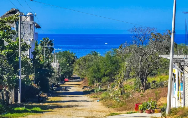 Beautiful tropical and natural city and seascape landscape panorama view with pacific ocean sea palms palm trees and beach with waves of Zicatela Puerto Escondido Oaxaca Mexico.