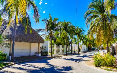 Tipik ve renkli paradisiacal cadde evleri, daireleri restoranları, restoranları, araba dükkanları palmiye ağaçları ve Bacocho ve Rinconada Puerto Escondido Oaxaca Meksika 'daki insanlar..