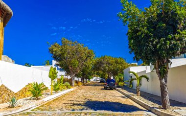 Tipik ve renkli paradisiacal cadde evleri, daireleri restoranları, restoranları, araba dükkanları palmiye ağaçları ve Bacocho ve Rinconada Puerto Escondido Oaxaca Meksika 'daki insanlar..