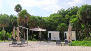 Playa del Carmen Meksika 'daki tropik Meksika plajındaki sahil otelindeki şemsiyeler ve güneş panzeleri..