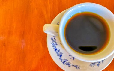 Zicatela Puerto Escondido Mexico 'daki El Cafecito' daki ahşap masada siyah kahve fincanı..