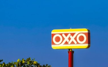 Puerto Escondido Oaxaca Meksika 16. Ocak 2023 Oxxo süpermarket logosu ve Zicatela Puerto Escondido Oaxaca Meksika 'da mavi bulutlu gökyüzü.