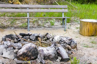Schwanewede Osterholz Almanya 'sındaki Harrier Kum Adası' nda bir park bankının yanında kamp ateşi yakın..