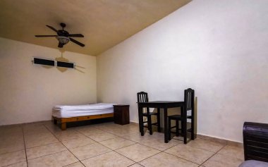 Playa del Carmen Quintana Roo Mexico 'da yatak odası, tuvalet TV ve buzdolabı olan basit bir otel odası..