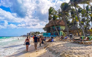 Playa del Carmen Quintana Roo Meksika 17. Nisan 2021 Tropikal Meksika Karayipler plaj manzarası berrak turkuaz mavi sularla insanlar Playa del Carmen Meksika 'daki otellere ve palmiye ağaçlarına gidiyor..