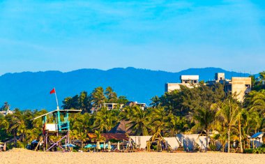 Puerto Escondido Oaxaca Meksika 16. Kasım 2022 Palmiye ağaçları Zicatela Puerto Escondido Oaxaca Mexico 'daki tropik Meksika plajındaki sahil otelindeki şemsiyeler ve güneş panzeleri..